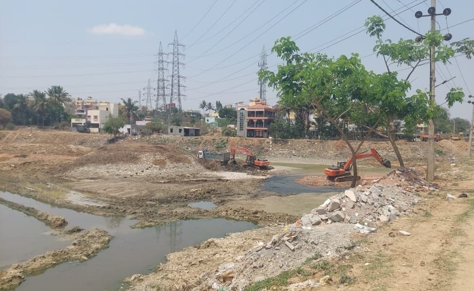 Mailsandra lake before rejuvenation with silt, debris, and excavation machinery